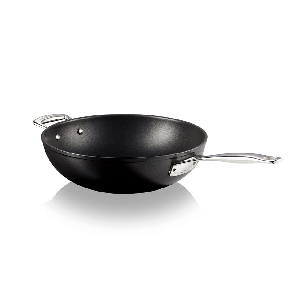 Black stir-fry pan with silver handles on a white background