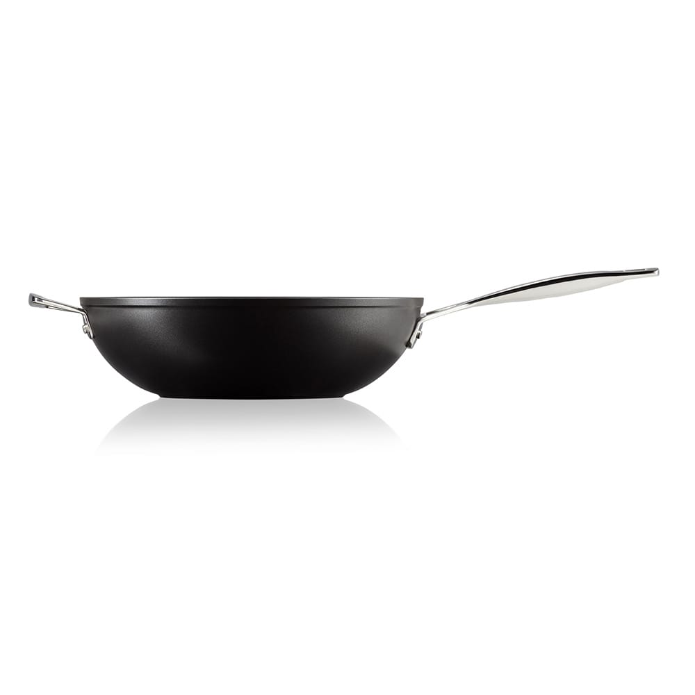 Black stir-fry pan with a silver handle on a white background