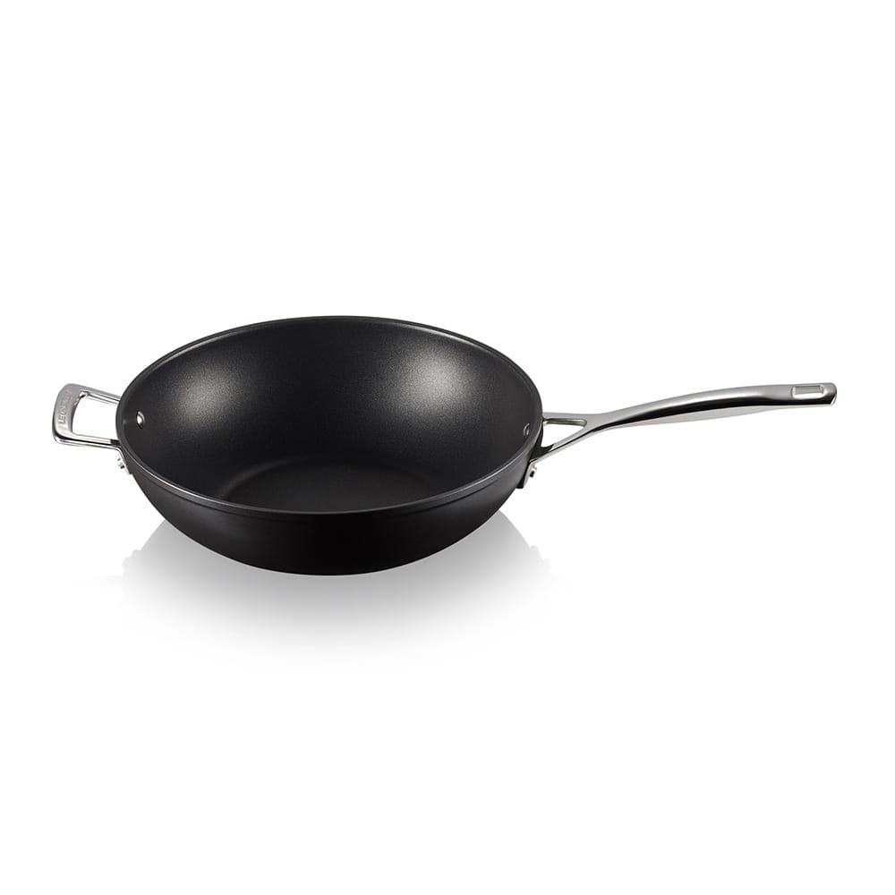 Black stir-fry pan with a silver handle on a white background