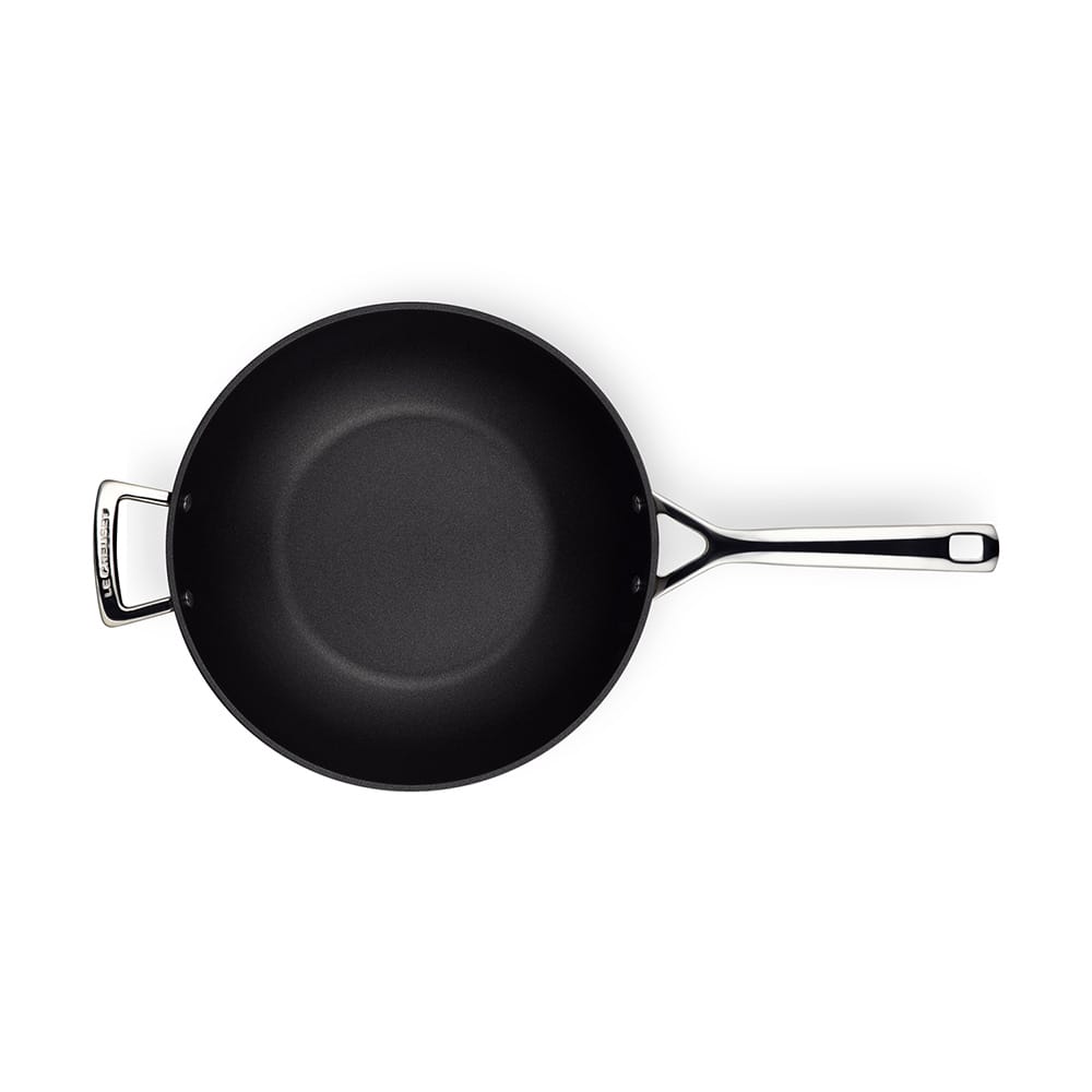 Black stir-fry pan with a silver handle on a white background