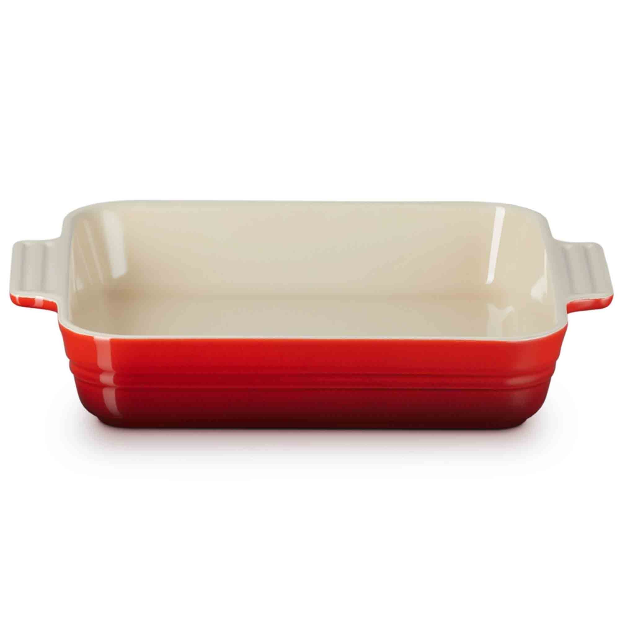 Cerise baking dish with red bottom and beige top on a white background