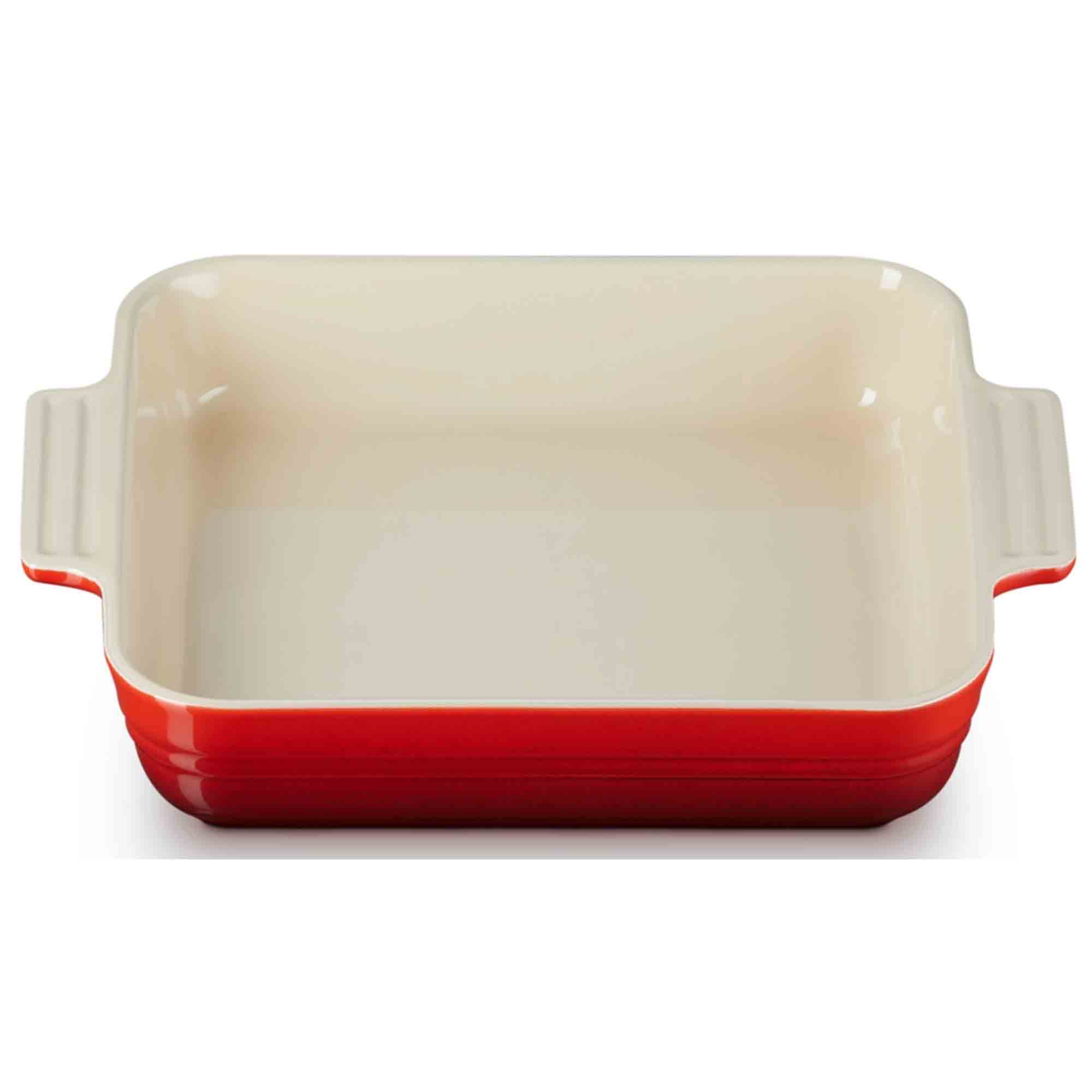 Cerise baking dish with red bottom and beige sides on a white background