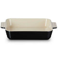 Baking dish with black base and cream-colored top on a white background