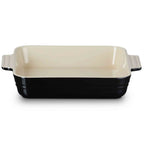 Baking dish with black base and cream-colored top on a white background