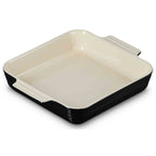 Square baking dish with beige interior and black exterior on a white background