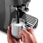 De'Longhi espresso machine with a person holding a milk frothing pitcher.