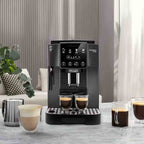 Black De'Longhi ECAM22022GB coffee machine on a table with glasses of coffee in a home setting.