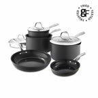 A 7-piece nonstick cookware set in matte black with stainless steel handles and lids, arranged on a white background. A circular 'Tried Tested' logo is visible in the top right corner.