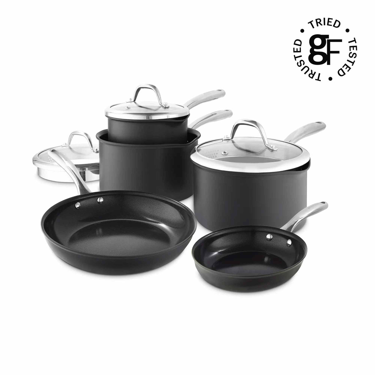 A 7-piece nonstick cookware set in matte black with stainless steel handles and lids, arranged on a white background. A circular 'Tried Tested' logo is visible in the top right corner.