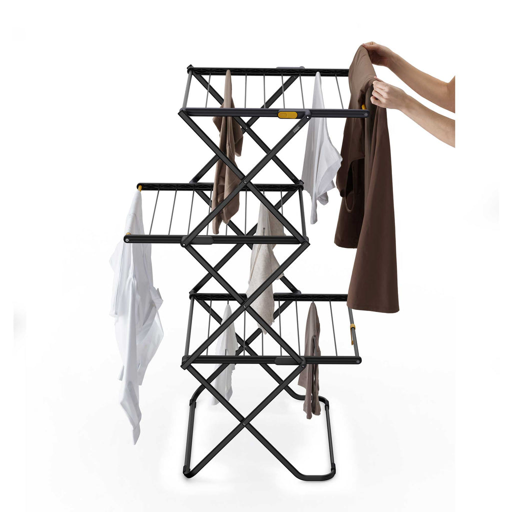 Black metal clothes rack with clothes on a white background