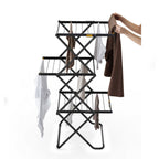 Black metal clothes rack with clothes on a white background