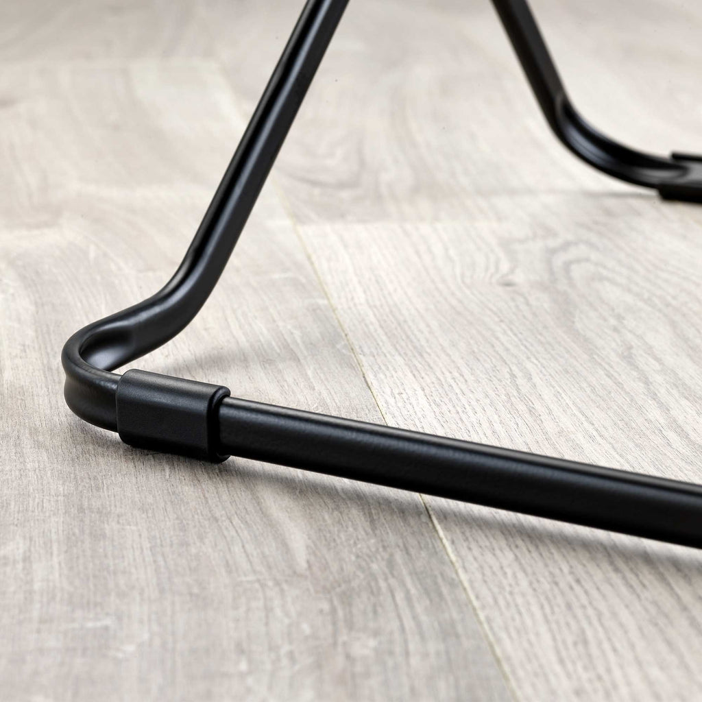 Close-up of a black metal clothes drier leg on a wooden floor