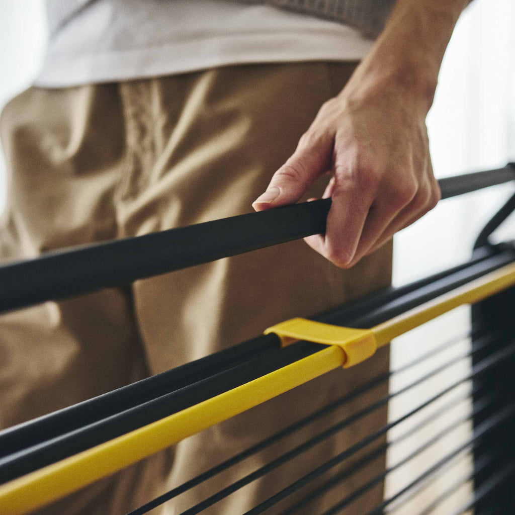 Person holding a black and yellow horizontal bar