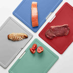 Four colorful cutting boards with different food items on a white background
