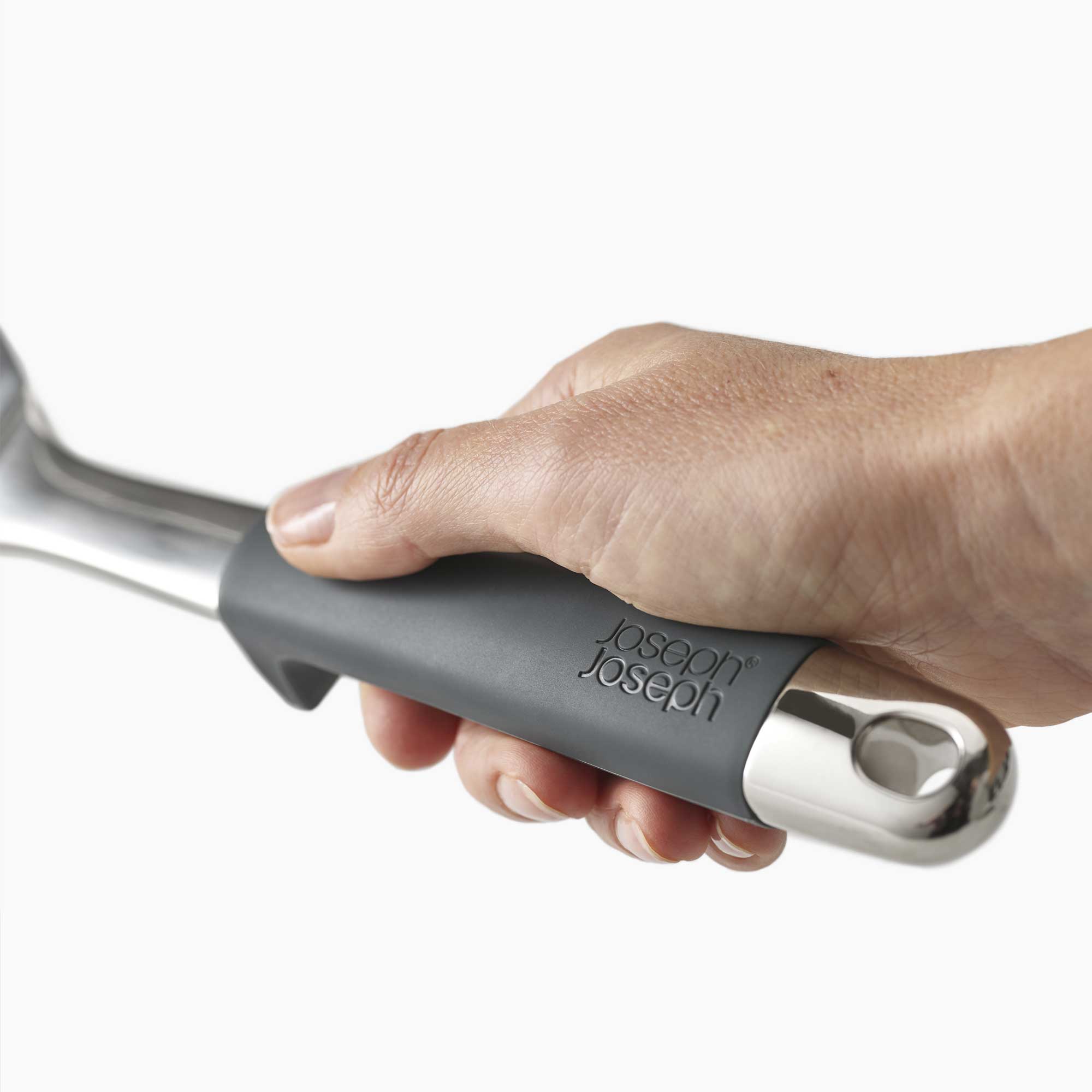 Hand holding a kitchen tool with 'Joseph Joseph' branding on a white background