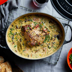 Satin black oval casserole with meat dish in creamy sauce