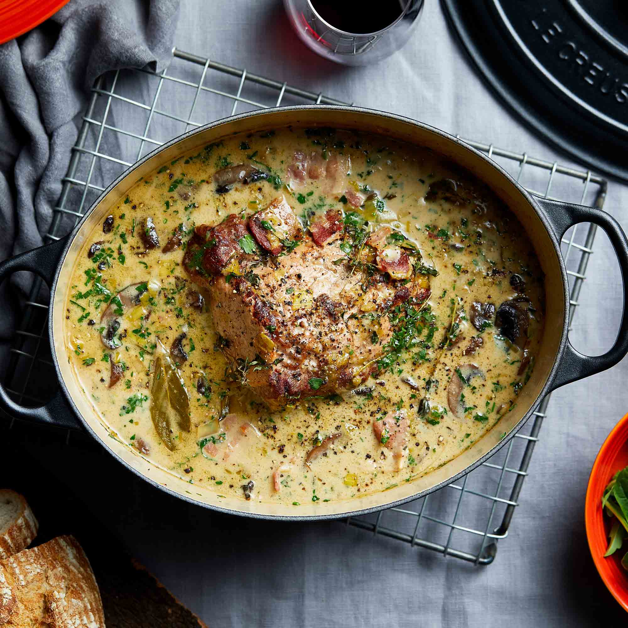 Satin black oval casserole with meat dish in creamy sauce