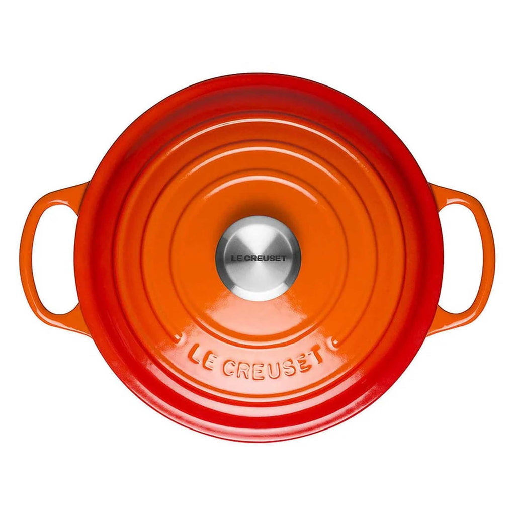 Orange Le Creuset pot lid on a white background