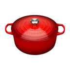 Red Le Creuset pot with a silver lid knob on a white background