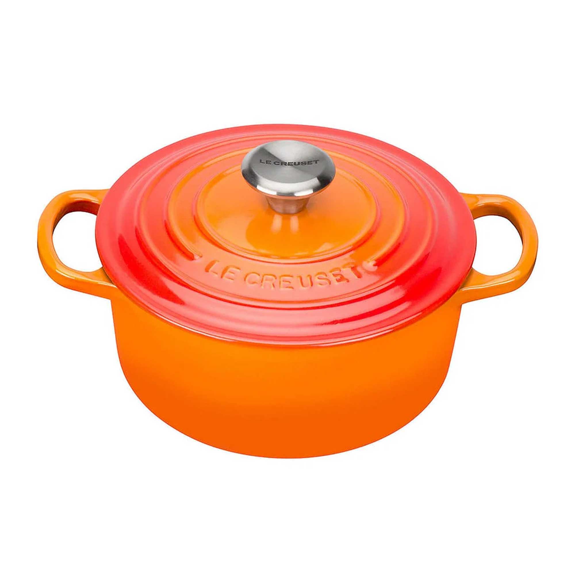 Orange enameled cast iron cookware with a red lid on a white background