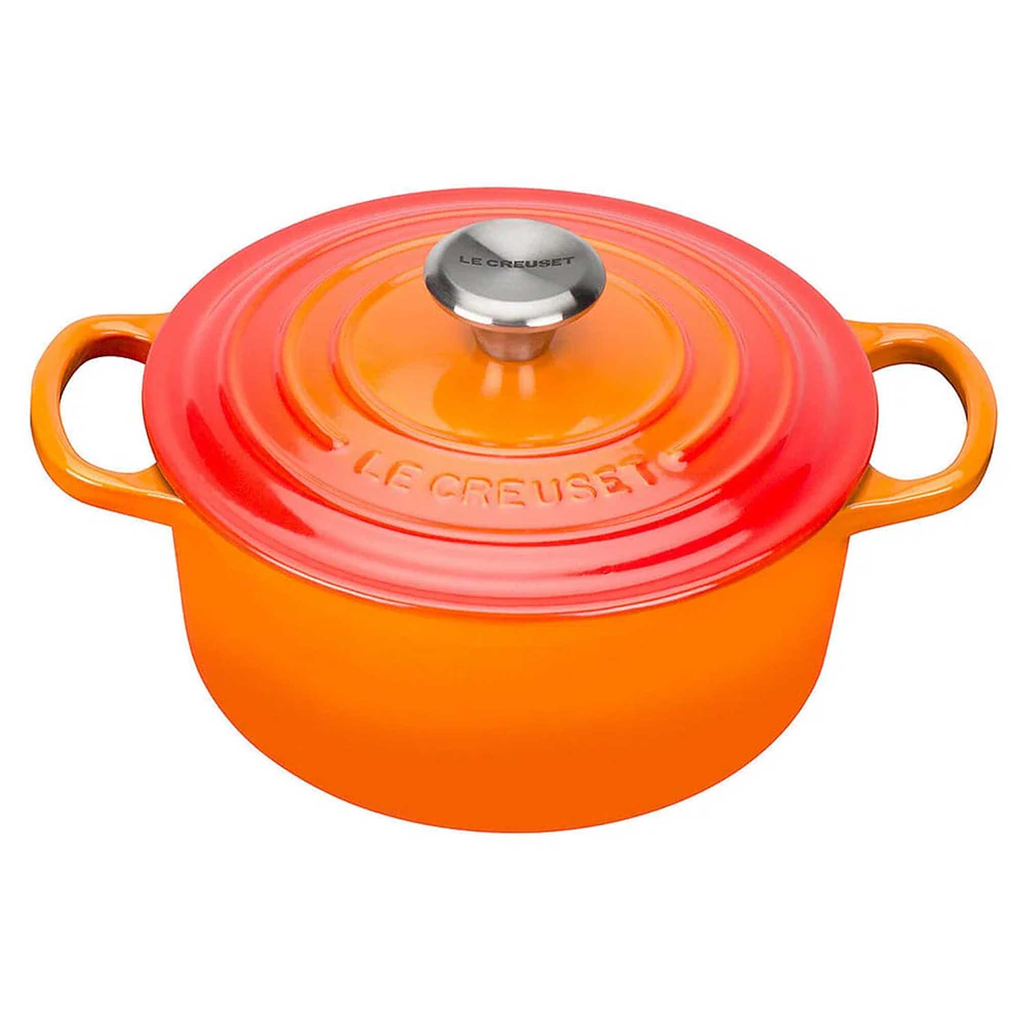 Orange Le Creuset pot with a lid on a white background