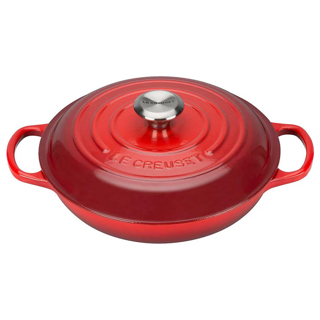 Red enameled cast iron cookware with lid on a white background