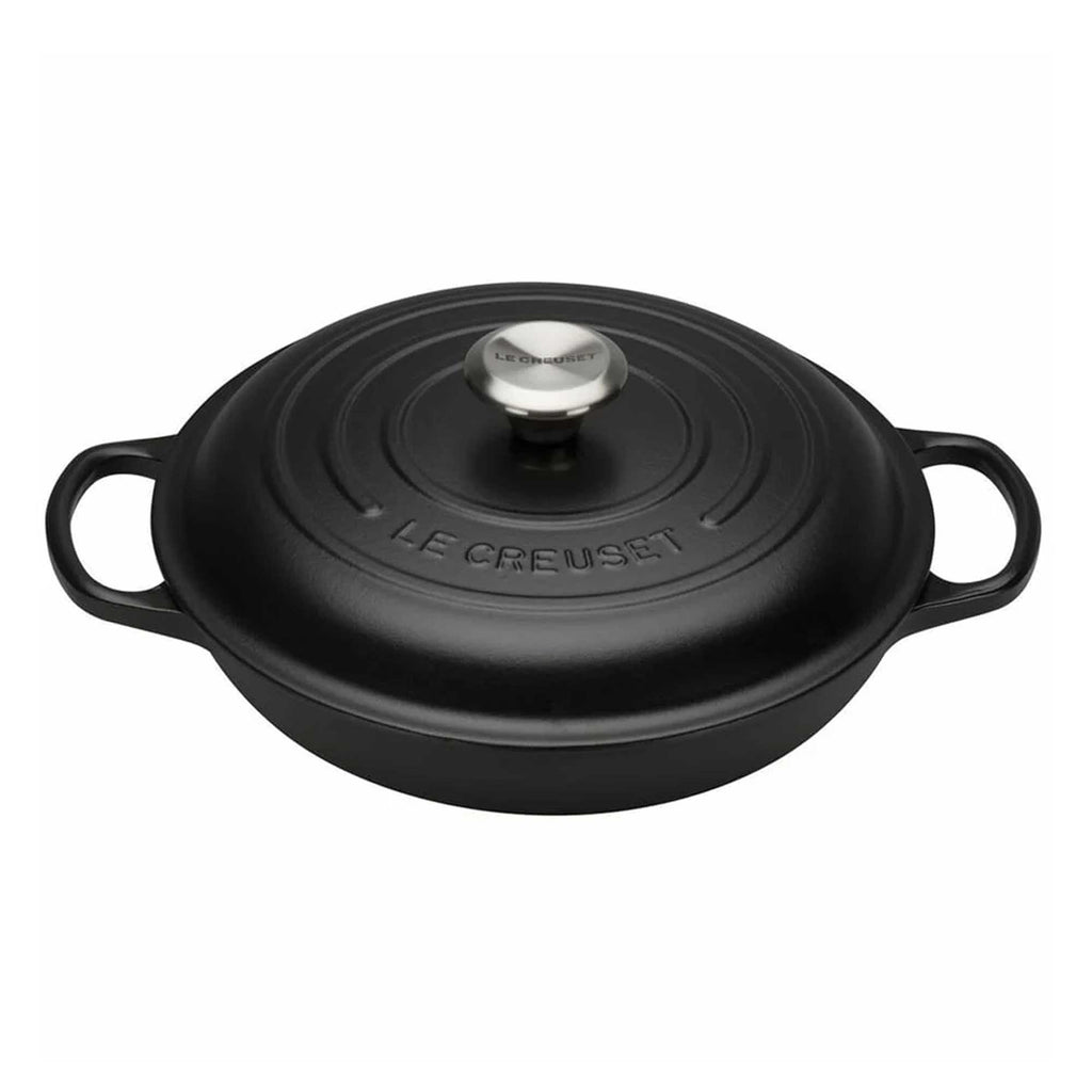 Black cast iron cookware with lid on a white background