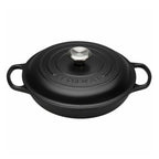 Black cast iron cookware with lid on a white background