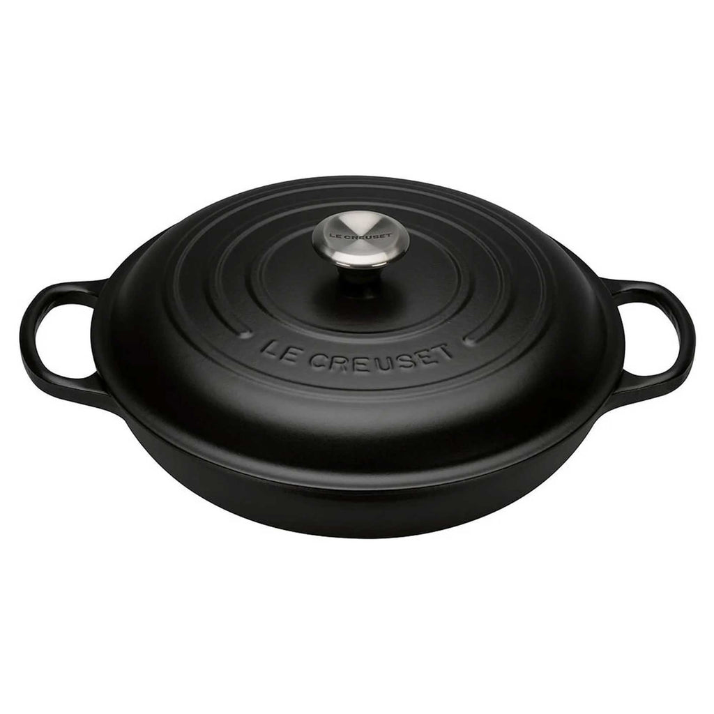 Black Le Creuset cast iron cocotte with lid on a white background