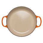 Round beige dish with orange handles on a white background