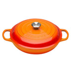 Orange enameled cast iron cookware with a lid on a white background