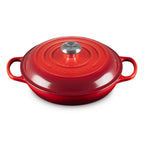 Red cast iron cookware with a silver handle on a white background