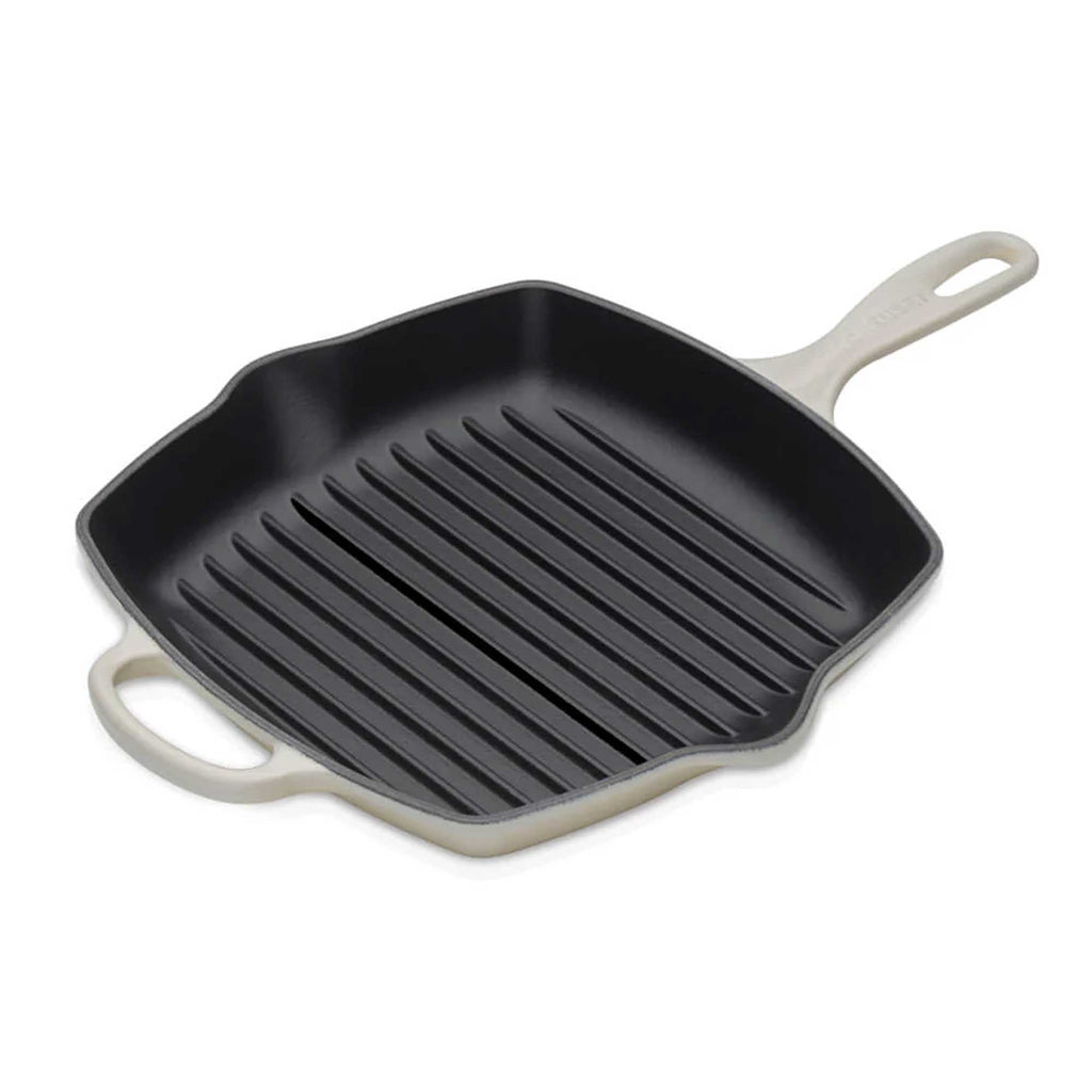 Black grill pan with beige handles on a white background