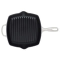 Black cast iron grill pan with white handles on a white background