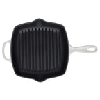 Black cast iron grill pan with white handles on a white background