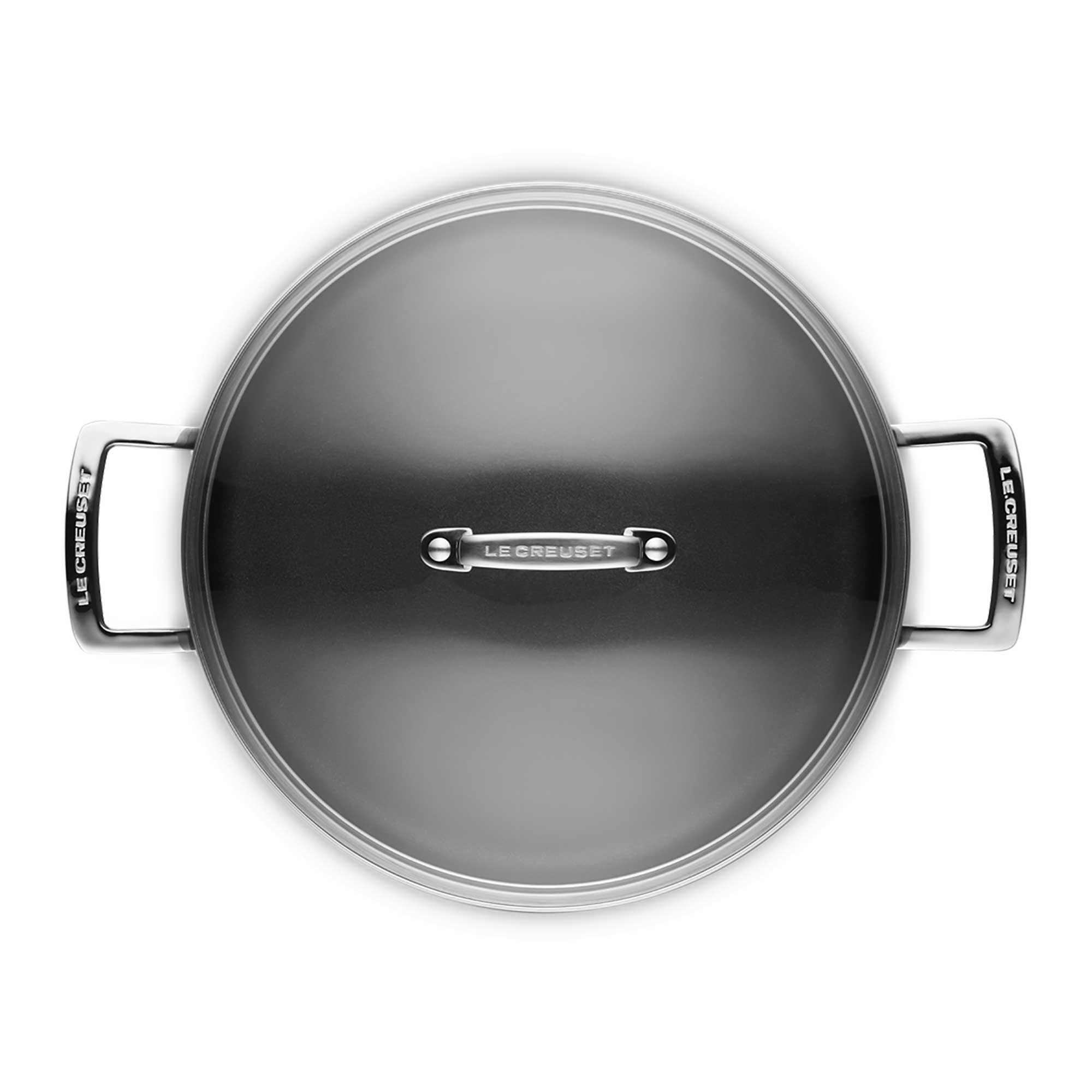 Top view of a Le Creuset pot with lid on a white background