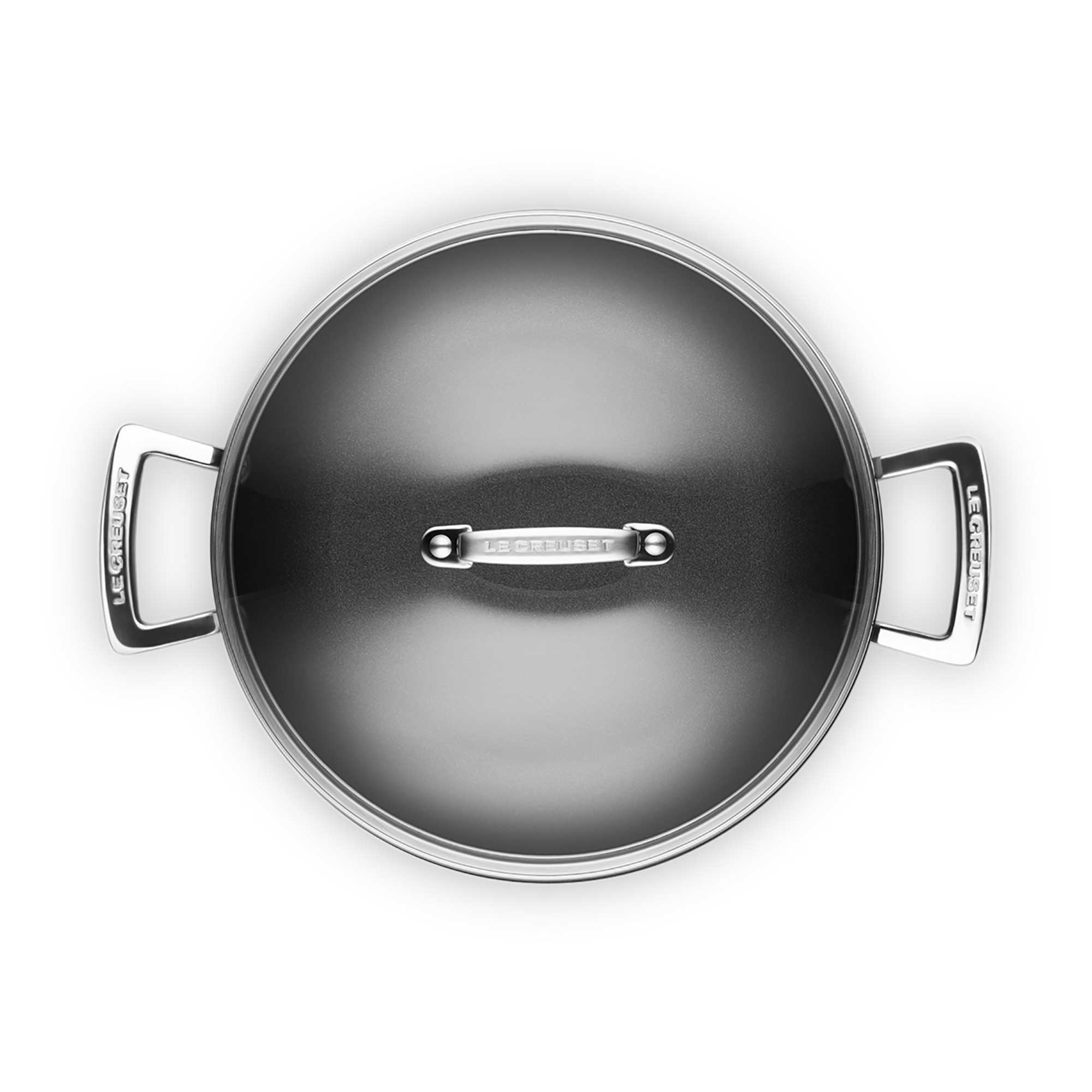 Shallow casserole with clear lid and silver handles on white background