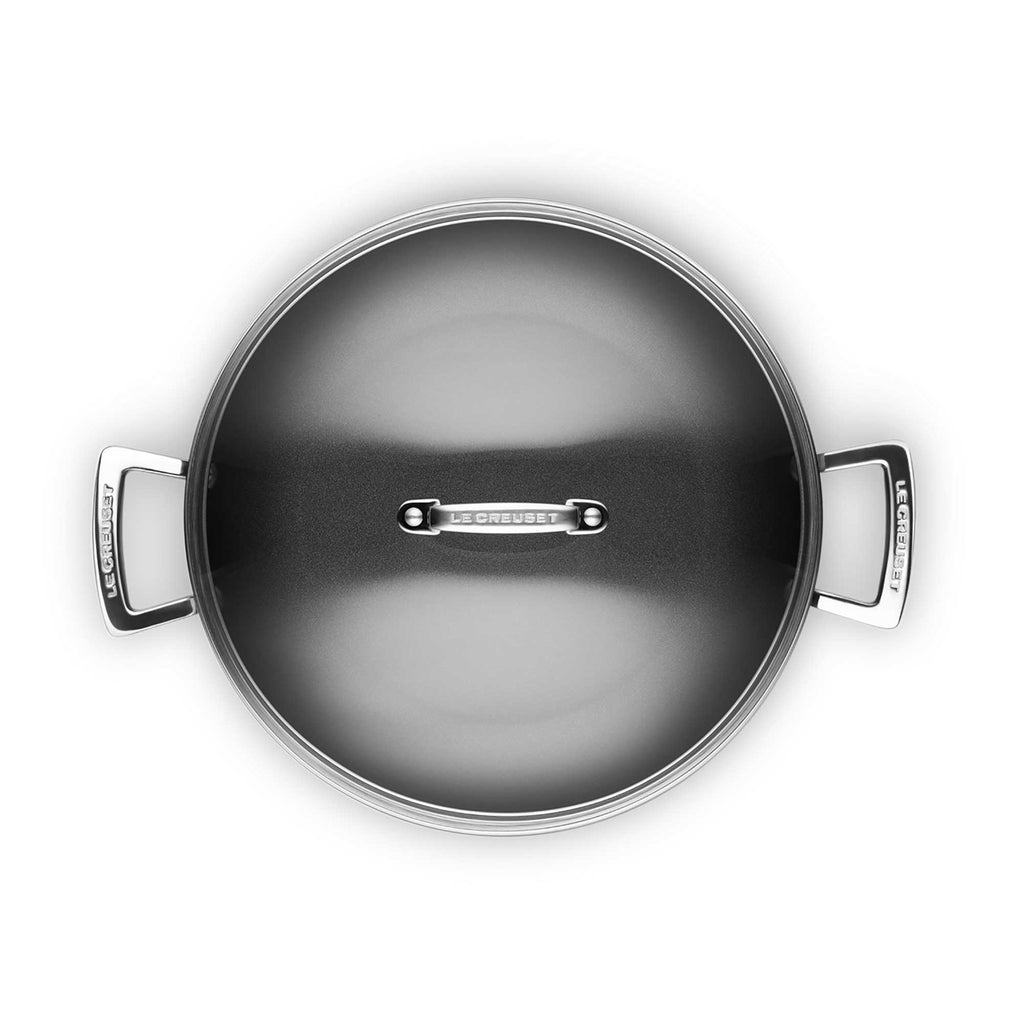 Top view of a Le Creuset cookware pot with lid on a white background