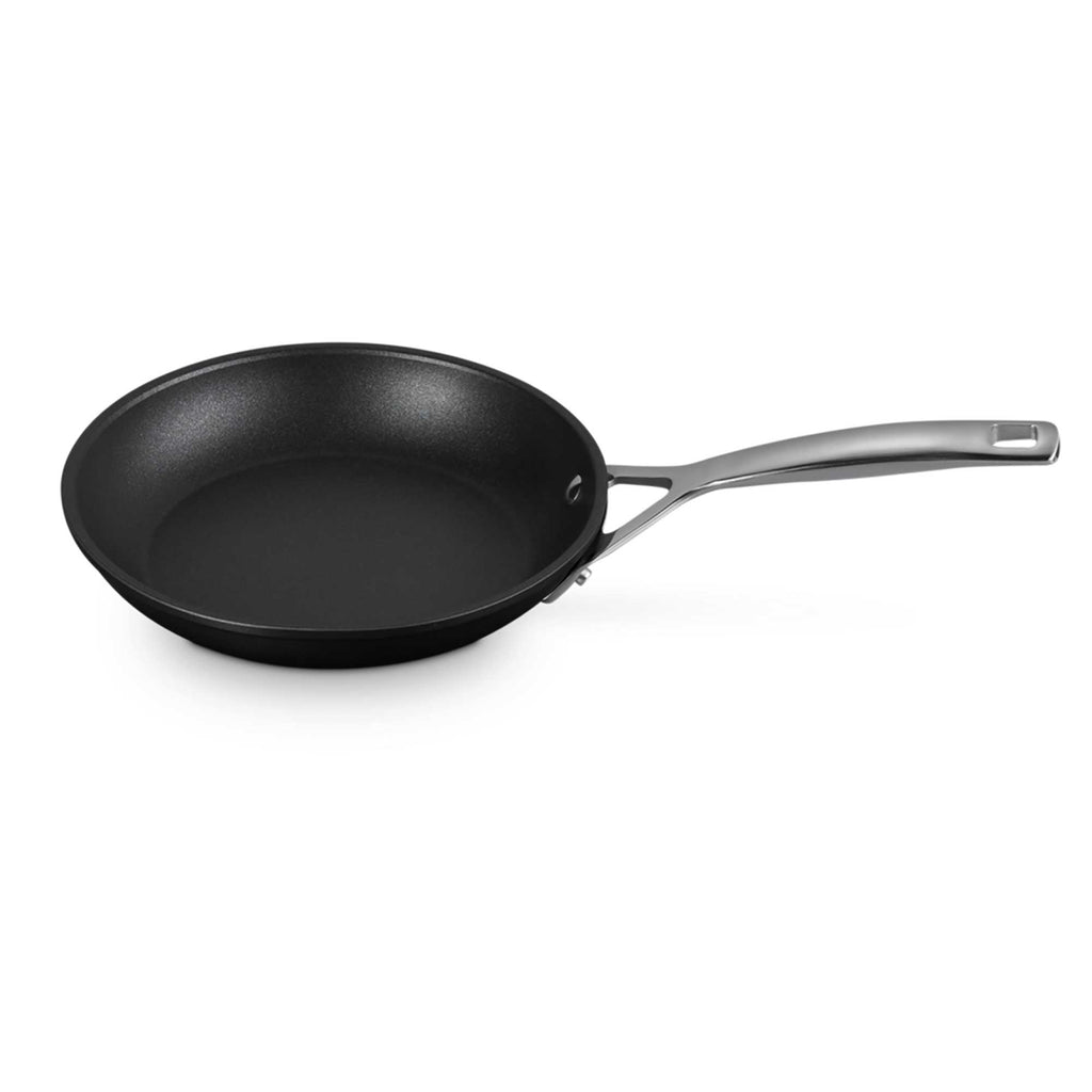 Black frying pan with a silver handle on a white background