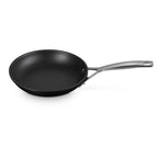 Black frying pan with a silver handle on a white background