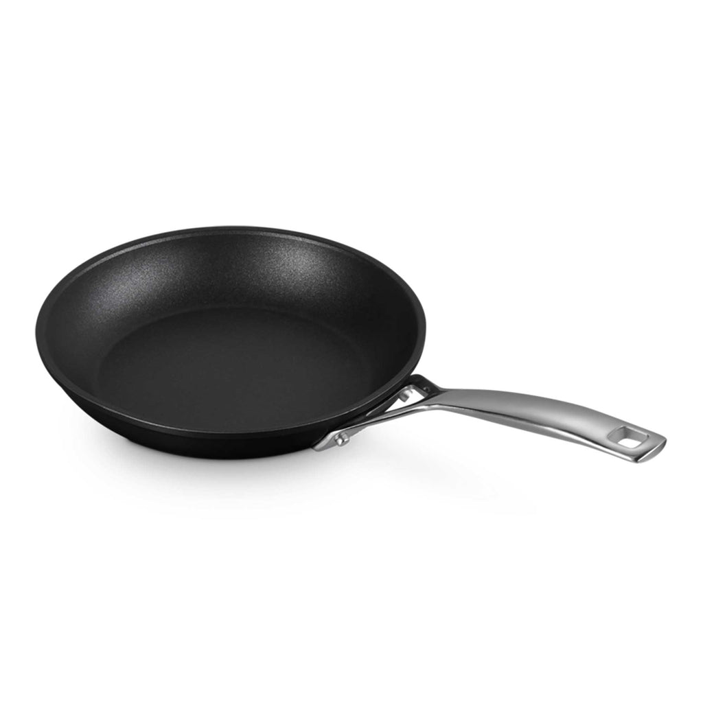 Black frying pan with a silver handle on a white background