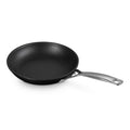Black frying pan with a silver handle on a white background