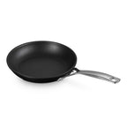 Black frying pan with a silver handle on a white background