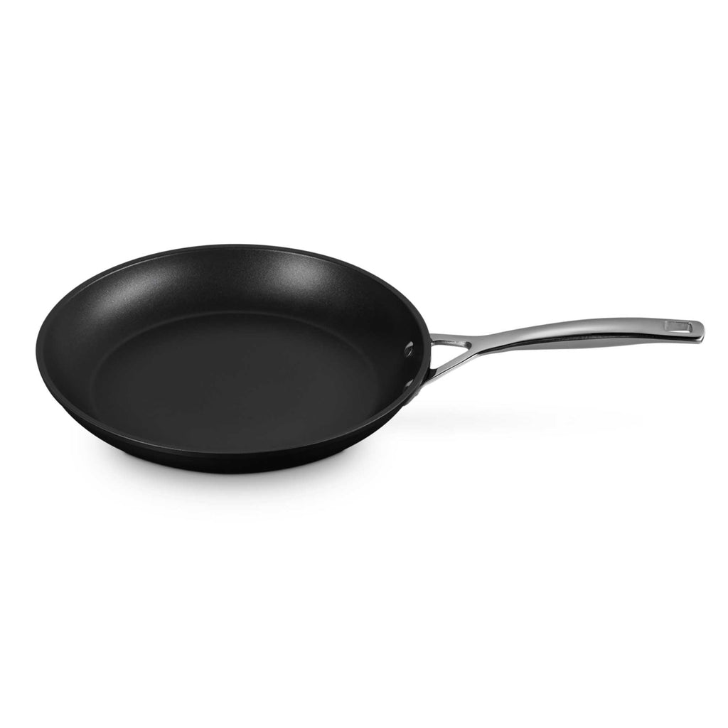 Black frying pan with a silver handle on a white background