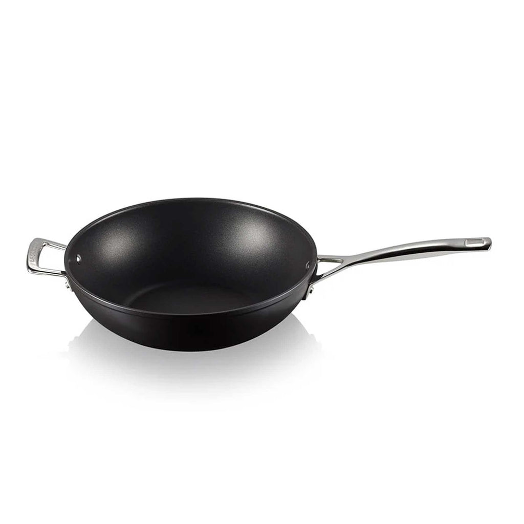 Black stir fry pan with a silver handle on a white background