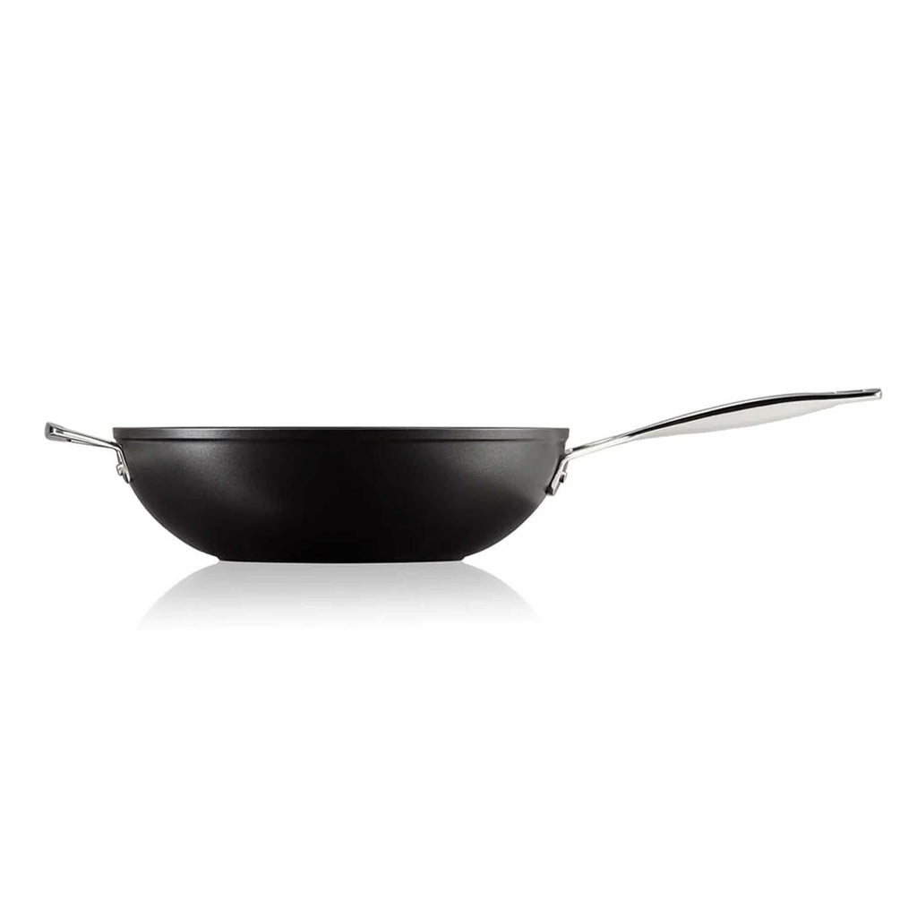 Black stir fry pan with a silver handle on a white background