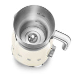 Stainless steel jug of a cream milk frother showing internal measuring lines with a white base on a white background