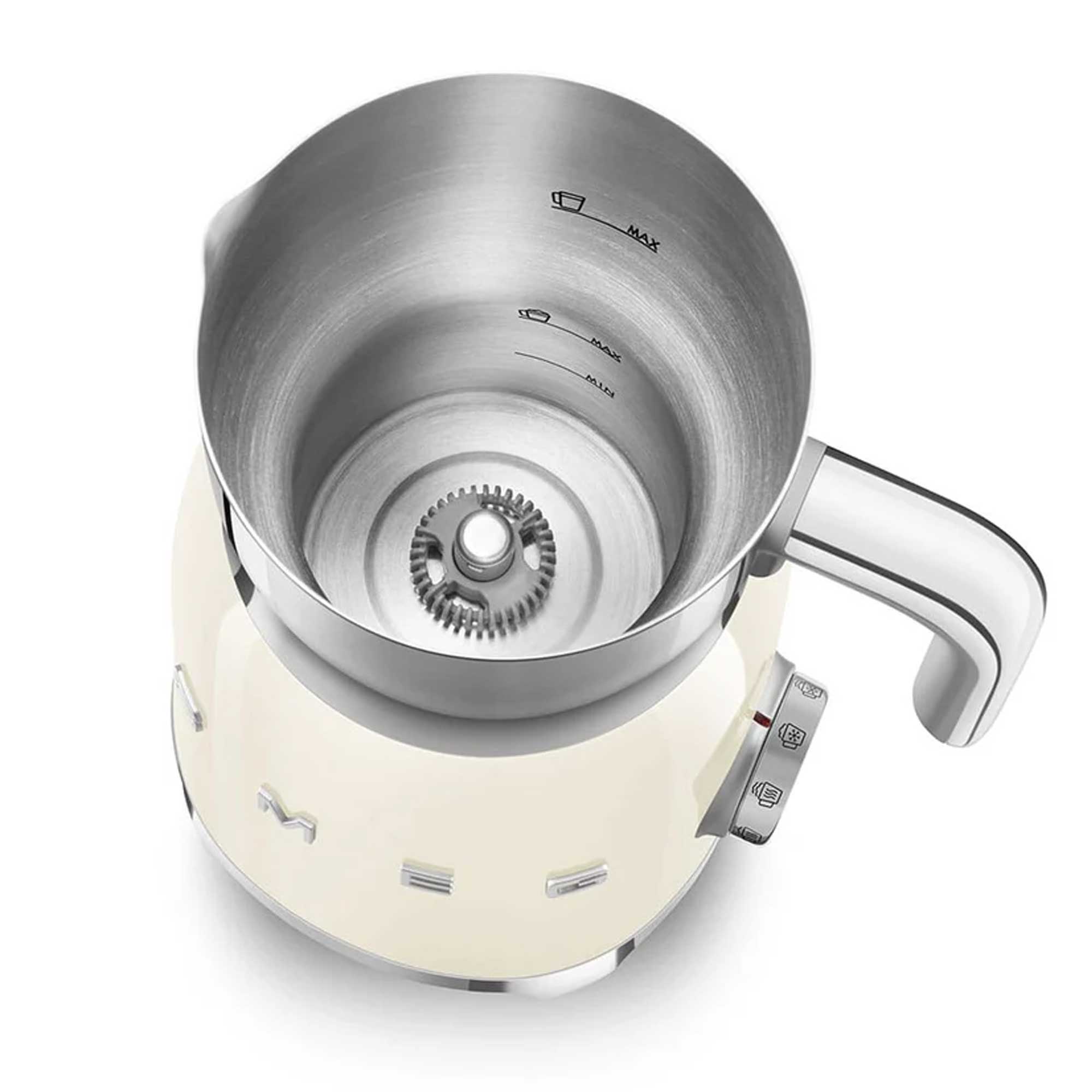 Stainless steel jug of a cream milk frother showing internal measuring lines with a white base on a white background