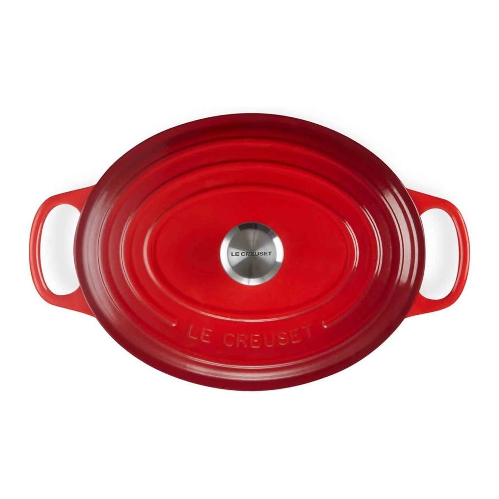 Cerise cast iron casserole dish with white handles on a white background, featuring Le Creuset branding.