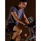 Man exercising on a stationary bike indoors using the Shark ChillPill to keep cool